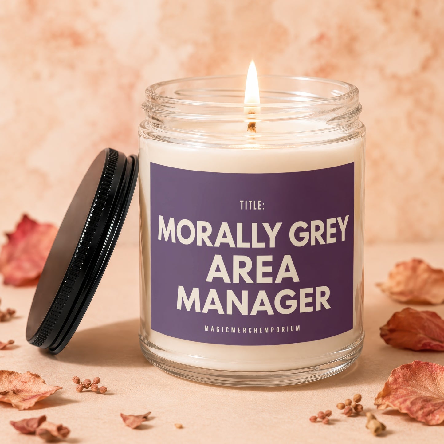 Candle with lit wick, "TITLE: MORALLY GREY AREA MANAGER" text, and scattered dried leaves.
