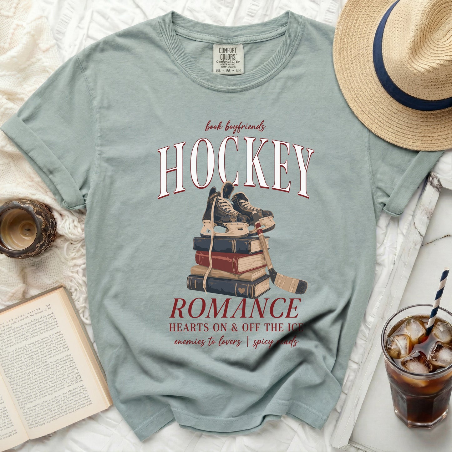 Pale blue t-shirt with "HOCKEY ROMANCE" text and ice skates on books.