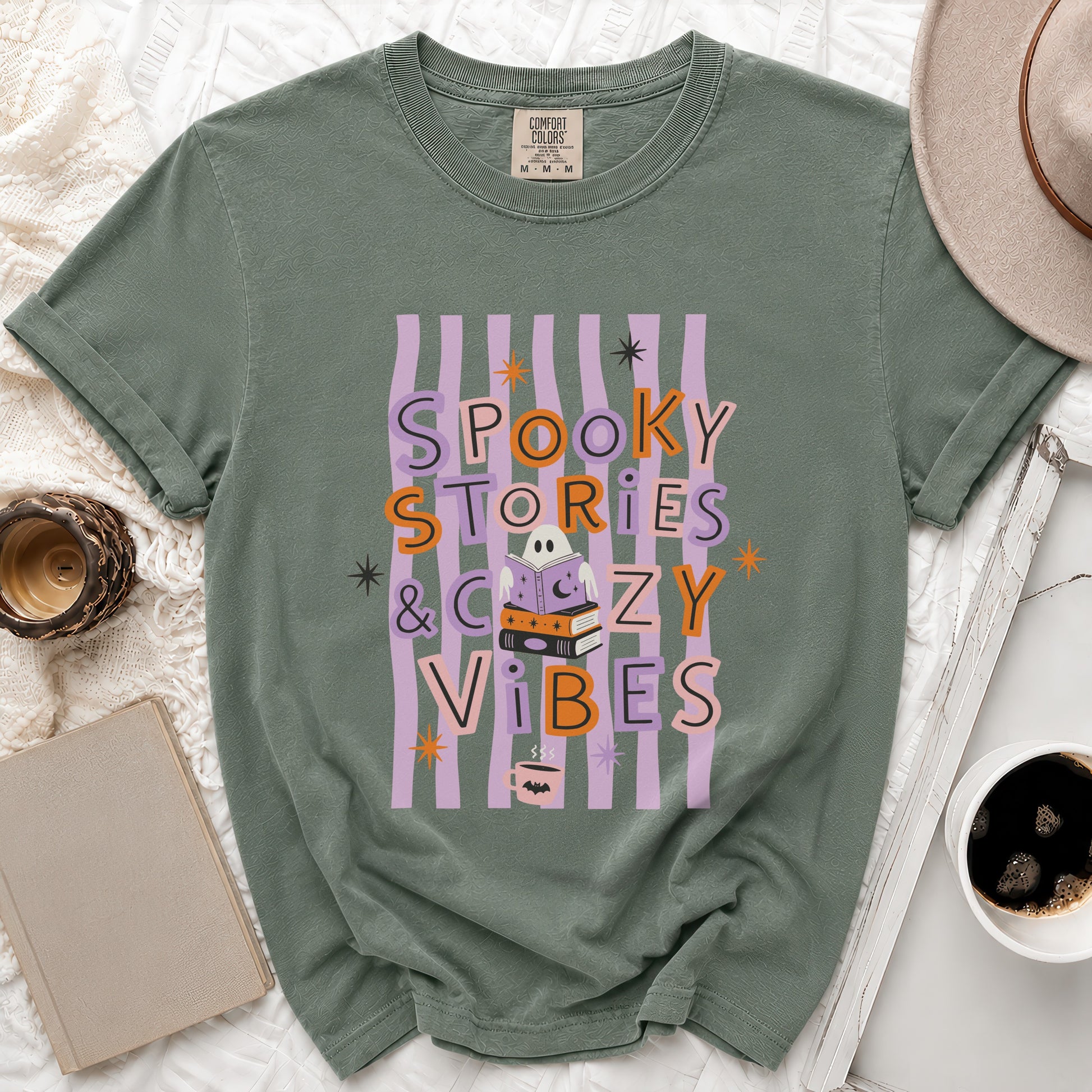 Green t-shirt with "Spooky Stories & Cozy Vibes" text and Halloween-themed graphics.