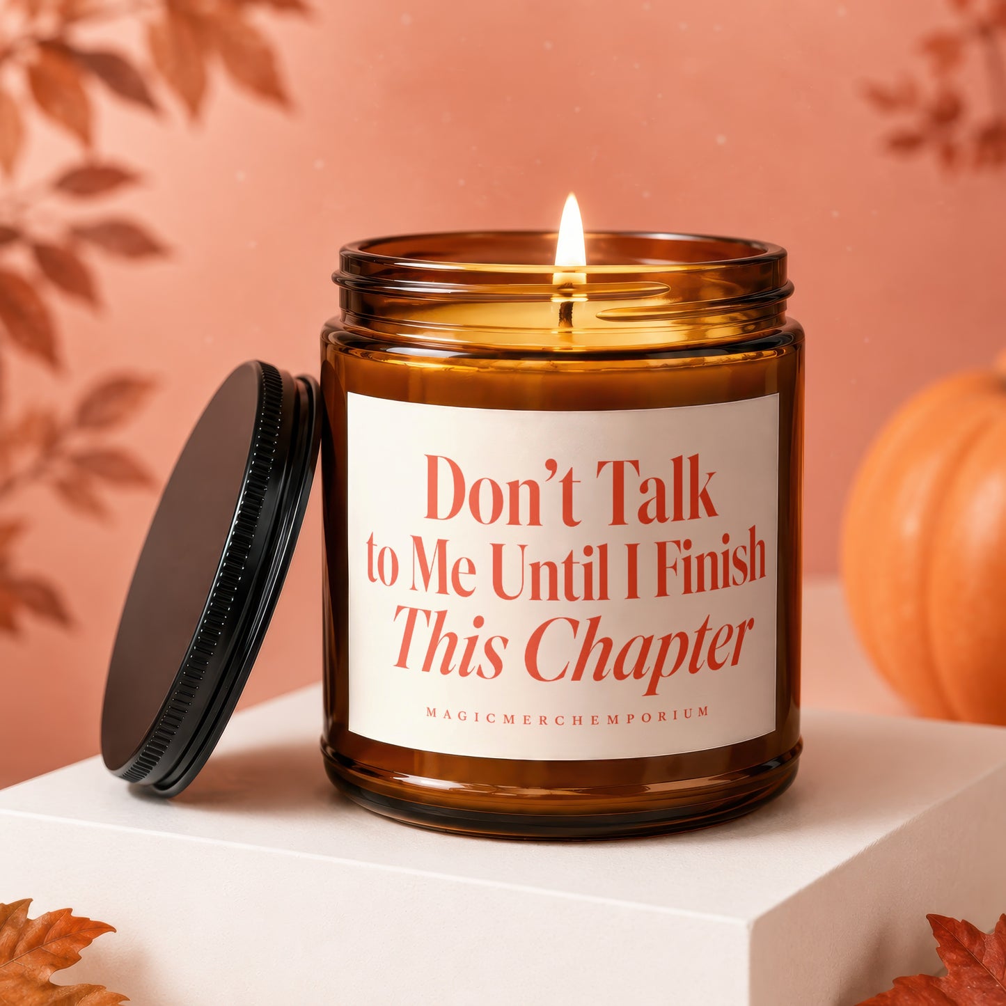 Amber candle with lit wick, lid off, and text "Don't Talk to Me Until I Finish This Chapter."