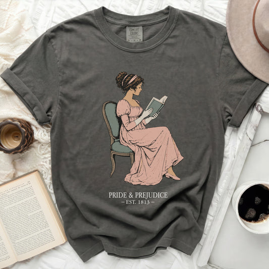 Dark gray t-shirt with illustration of a woman reading and "Pride & Prejudice est. 1813".