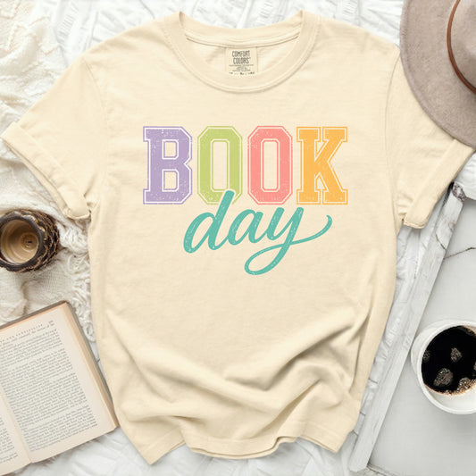 Comfort Colors t-shirt with "BOOK day" in colorful block letters.