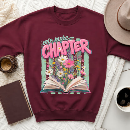 Maroon sweatshirt with "one more CHAPTER" text and blooming flowers graphic.