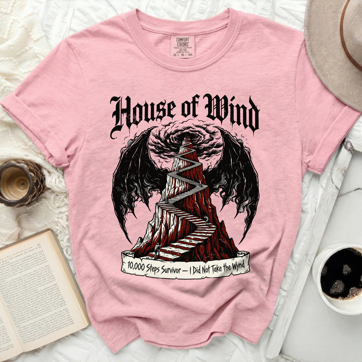 Pink t-shirt with "House of Wind" and a winding staircase with wings.