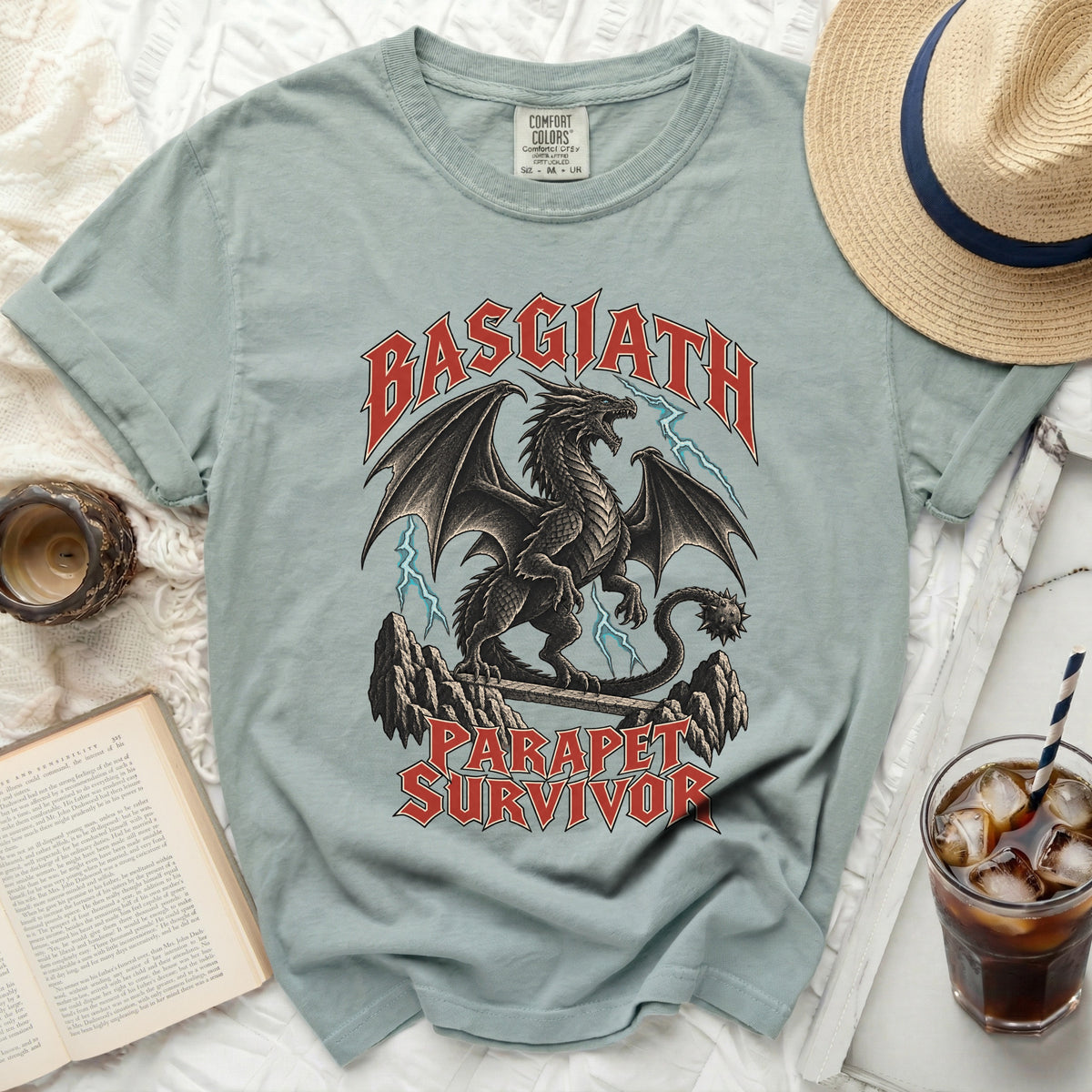 Light blue t-shirt with a black dragon graphic and text that reads "Basgiath Parapet Survivor".