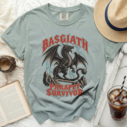 Light blue t-shirt with a black dragon graphic and text that reads "Basgiath Parapet Survivor".