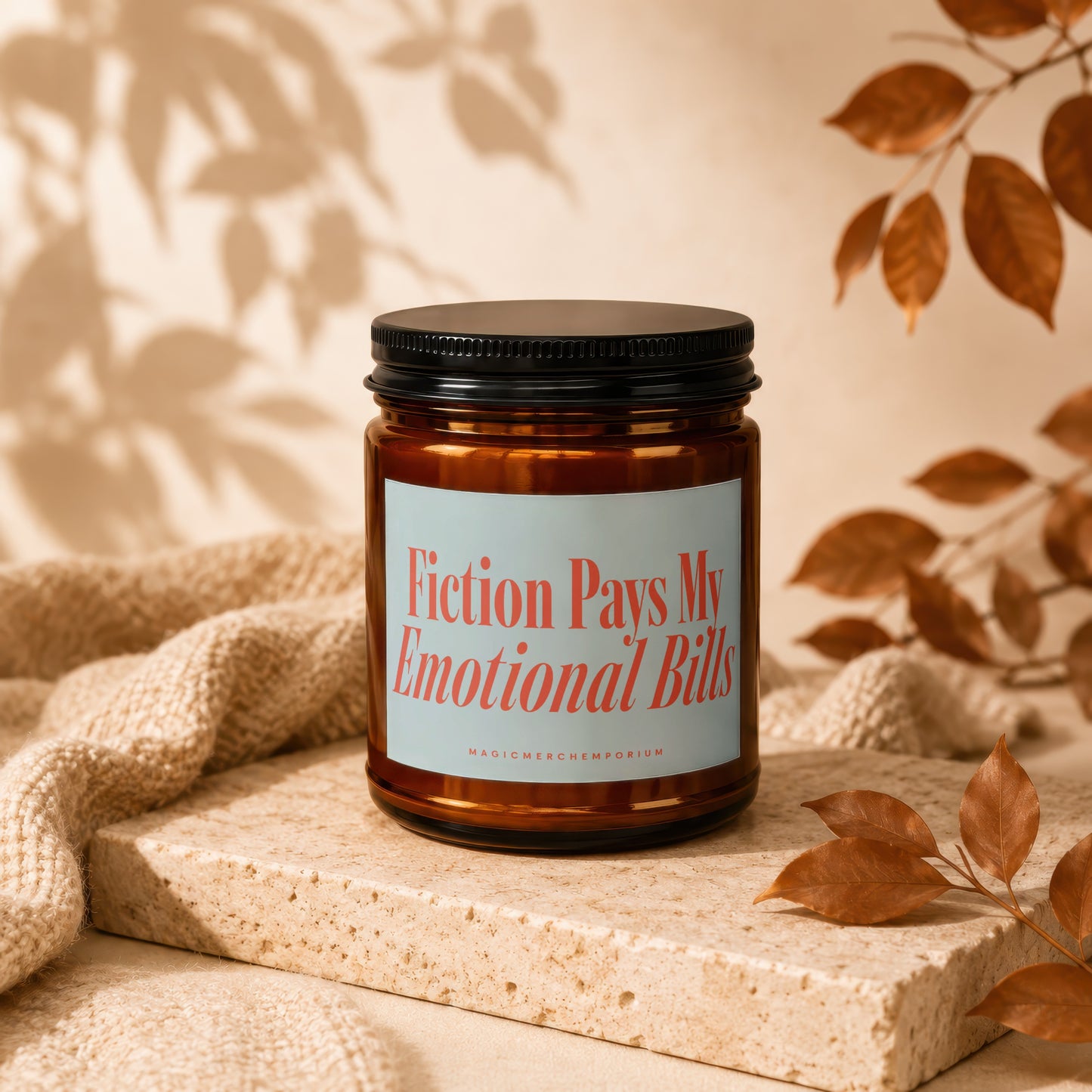Amber jar candle with a light blue label reading "Fiction Pays My Emotional Bills".