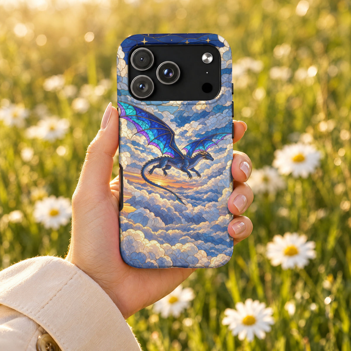 A hand holds a smartphone featuring a stained-glass design of a blue dragon flying through sunset clouds.