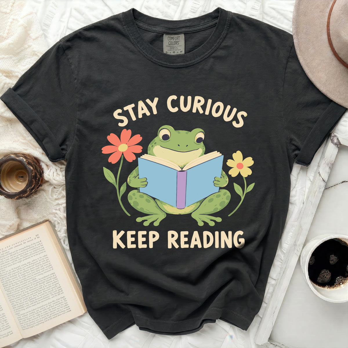 Frog reading book with flowers and text "Stay Curious Keep Reading"