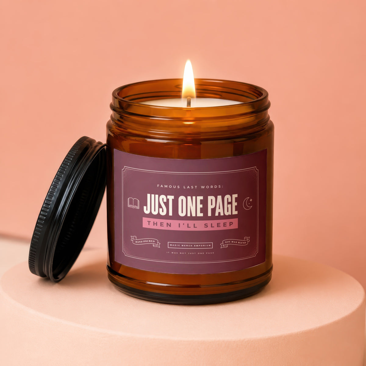 Amber glass candle with lit flame and label reading "Just One Page Then I'll Sleep".