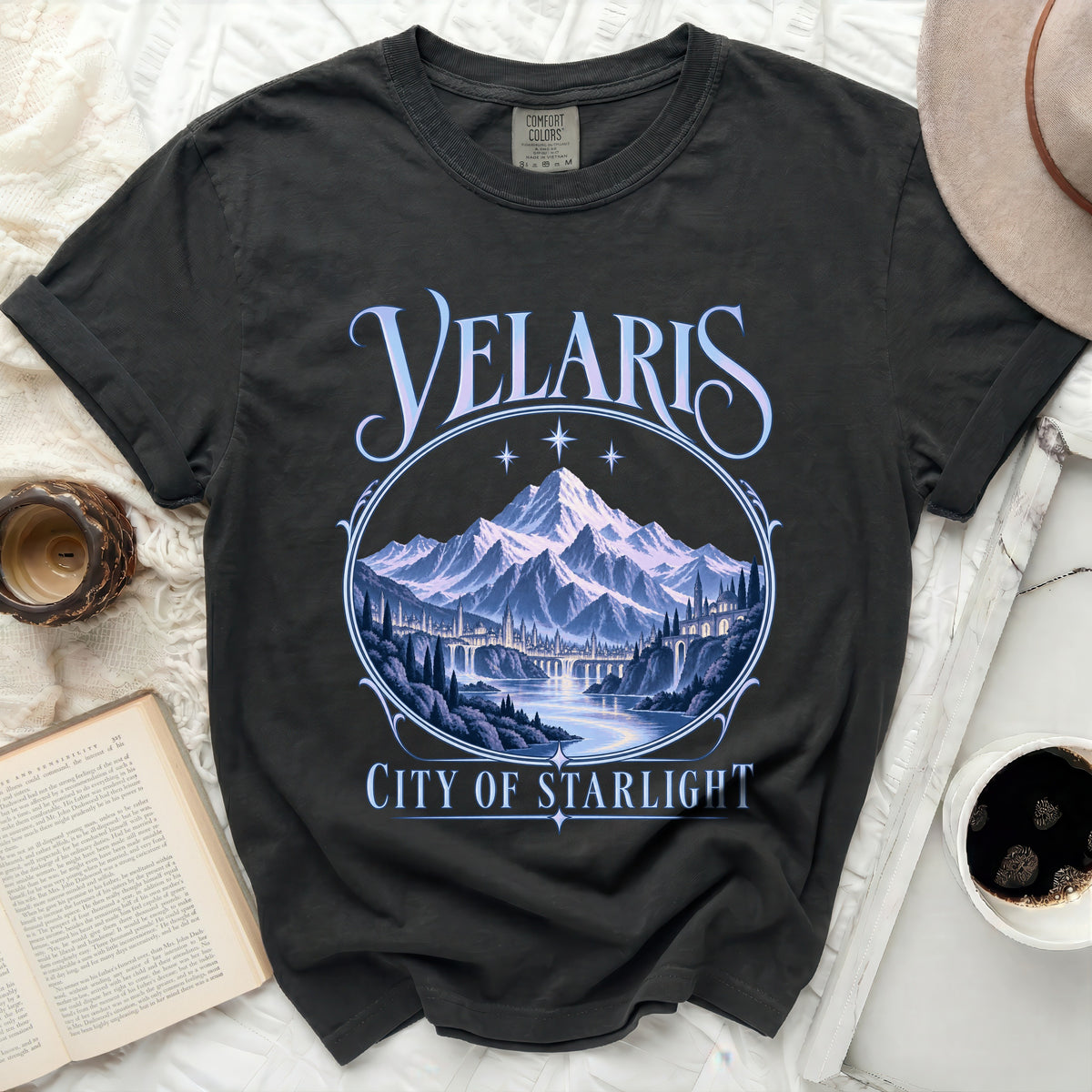 Dark t-shirt with "Velaris City of Starlight" text and a mountain city landscape graphic.