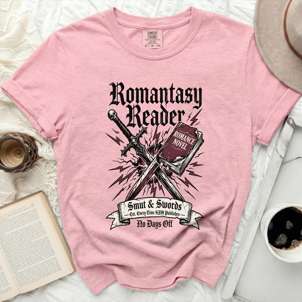 Pink t-shirt with "Romantasy Reader" text, sword, and book graphics.