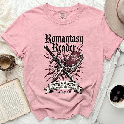 Pink t-shirt with "Romantasy Reader" text, sword, and book graphics.