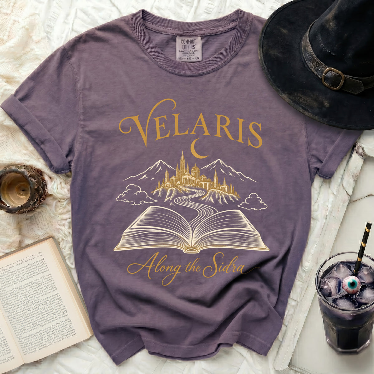Purple t-shirt with Velaris text, castle, and open book graphic.