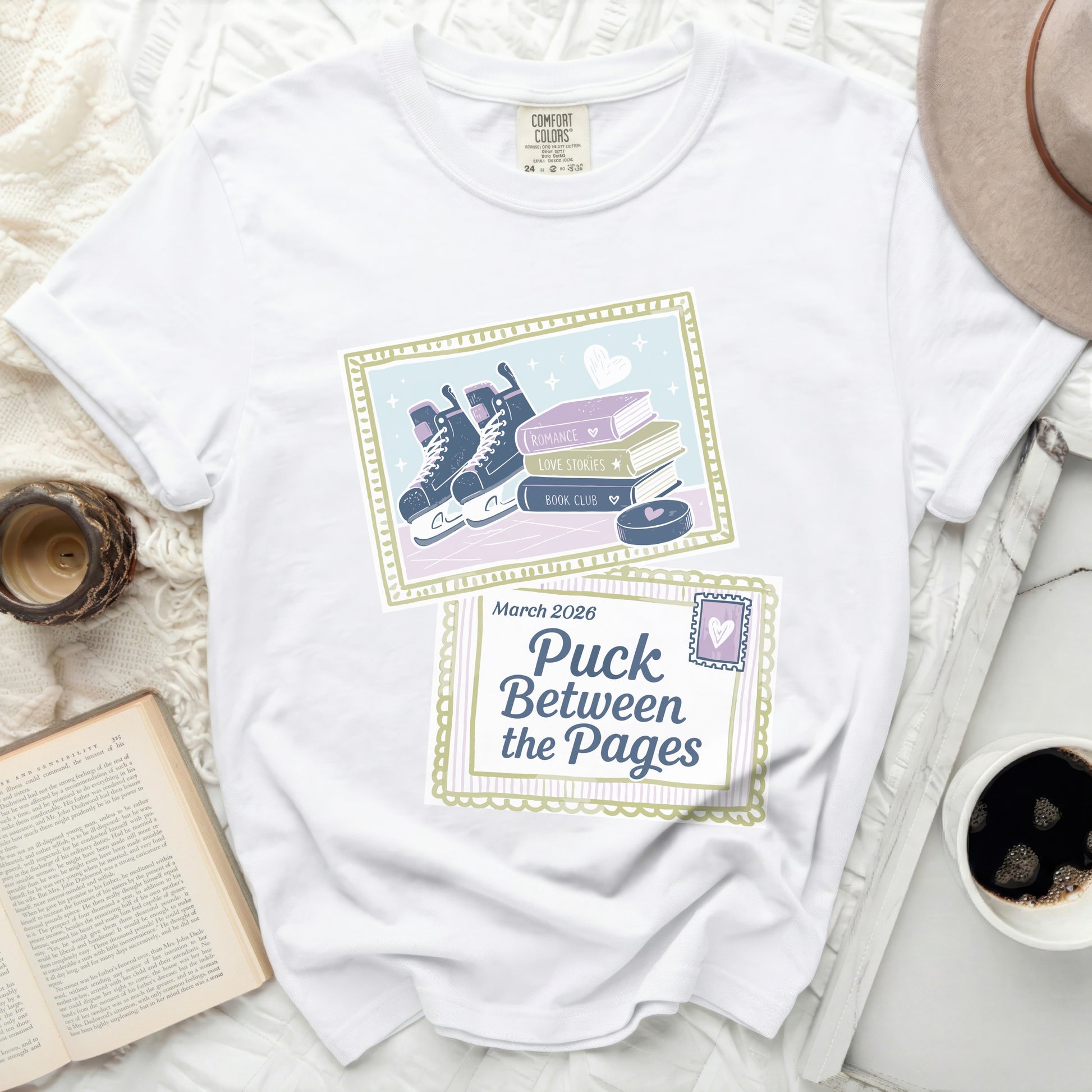 White t-shirt with "Puck Between the Pages" design featuring skates and books.