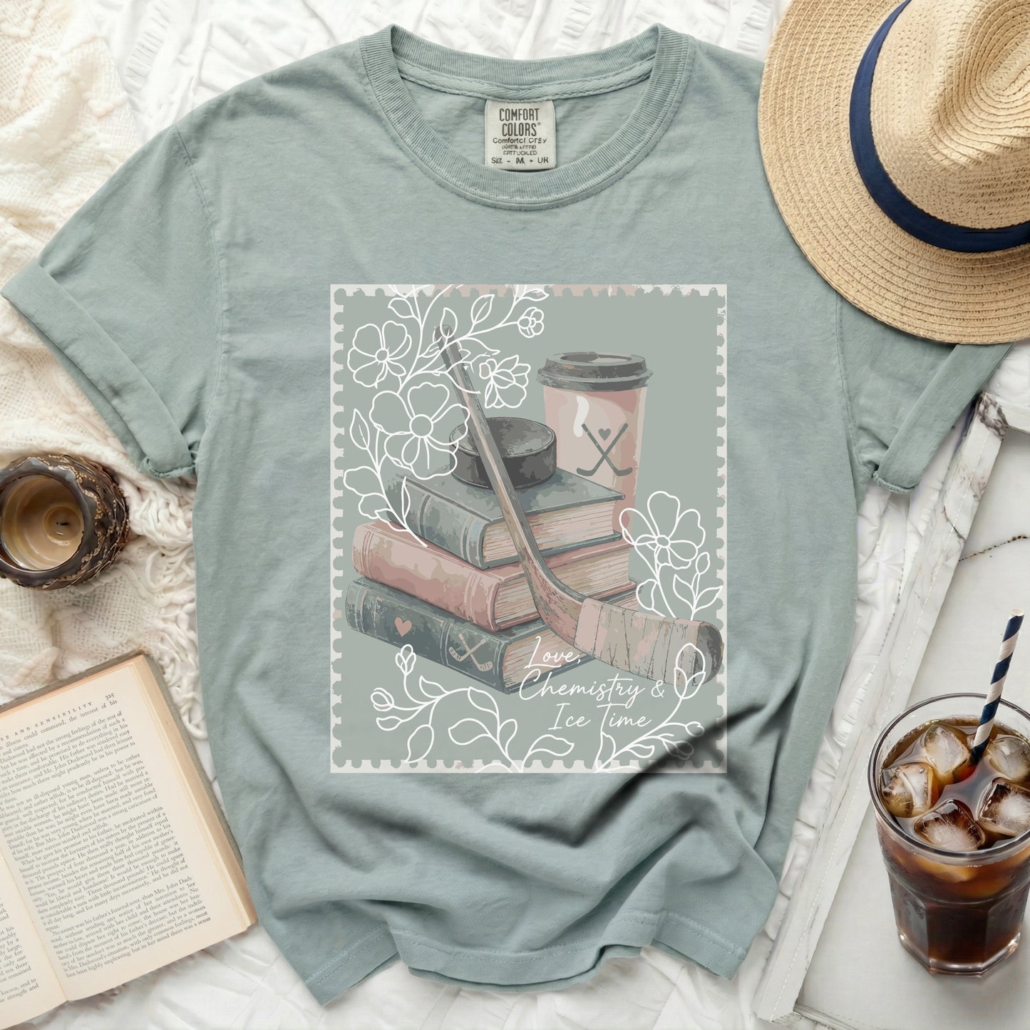 T-shirt with ice hockey equipment, books, and coffee cup illustration.