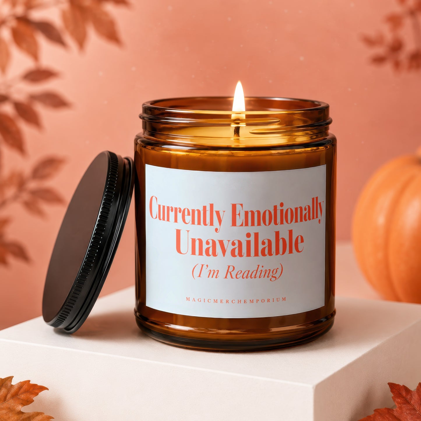 Amber glass candle with lit flame reads "Currently Emotionally Unavailable (I'm Reading)".