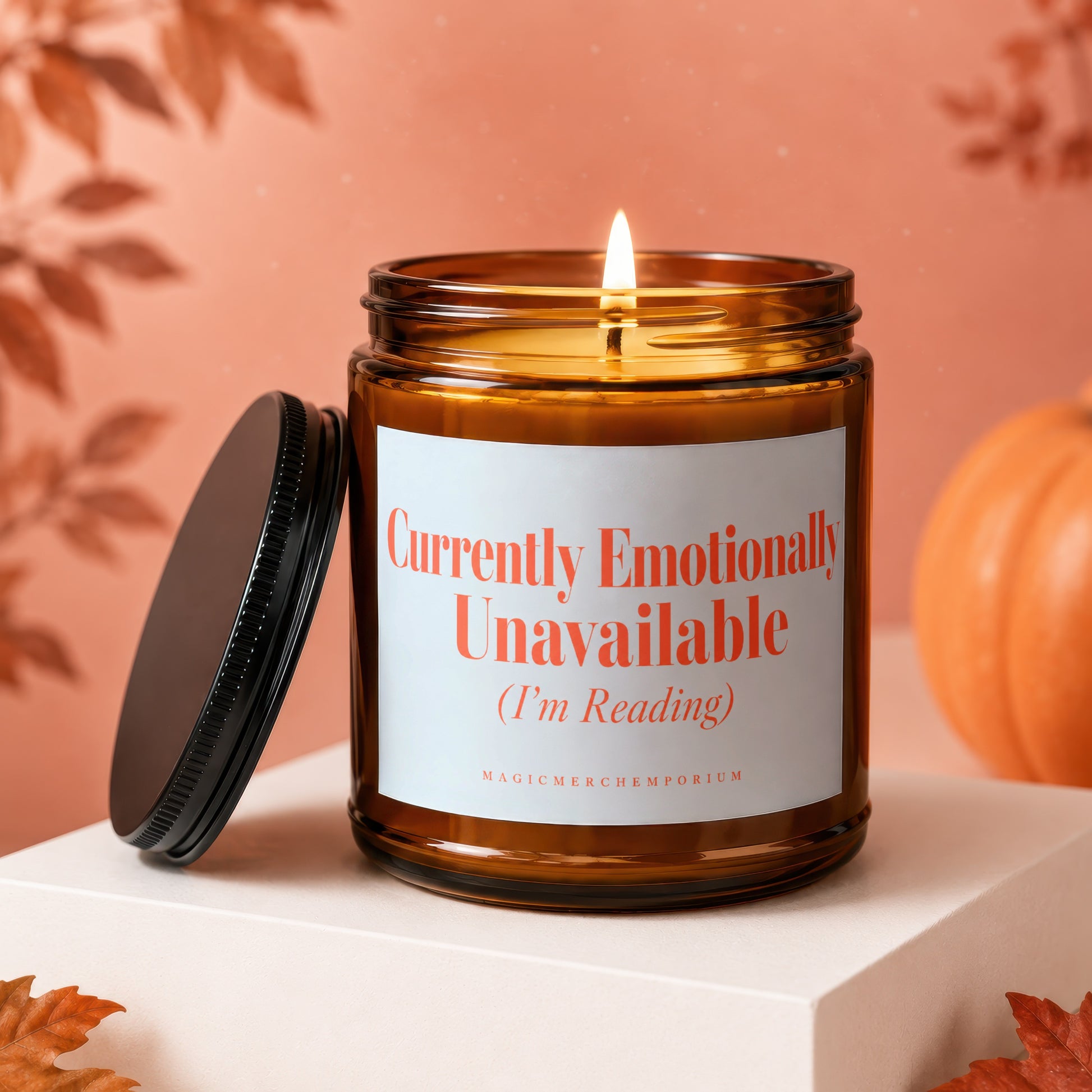 Amber glass candle with lit flame reads "Currently Emotionally Unavailable (I'm Reading)".