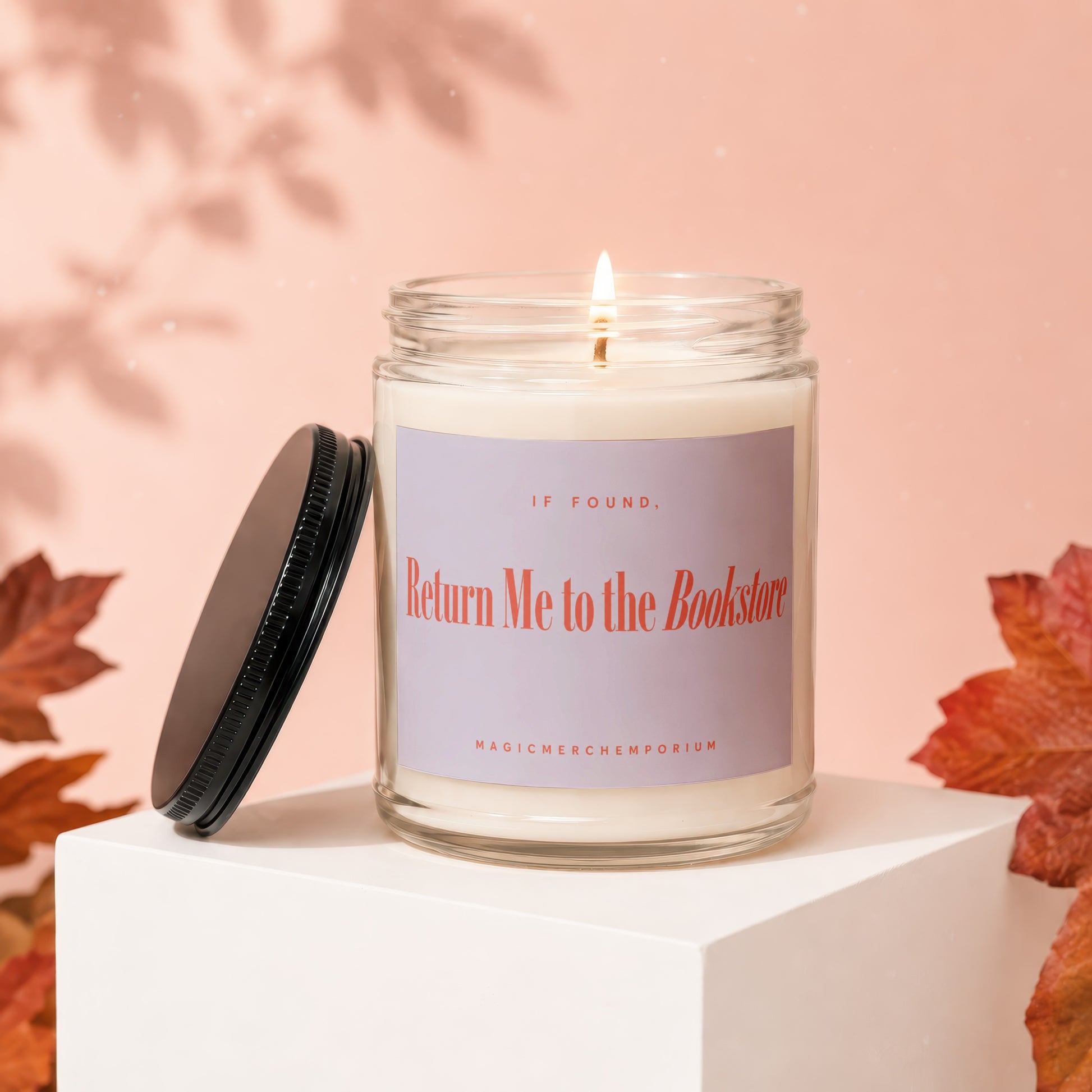 Candle with a lit wick and a label that reads "If Found, Return Me to the Bookstore".