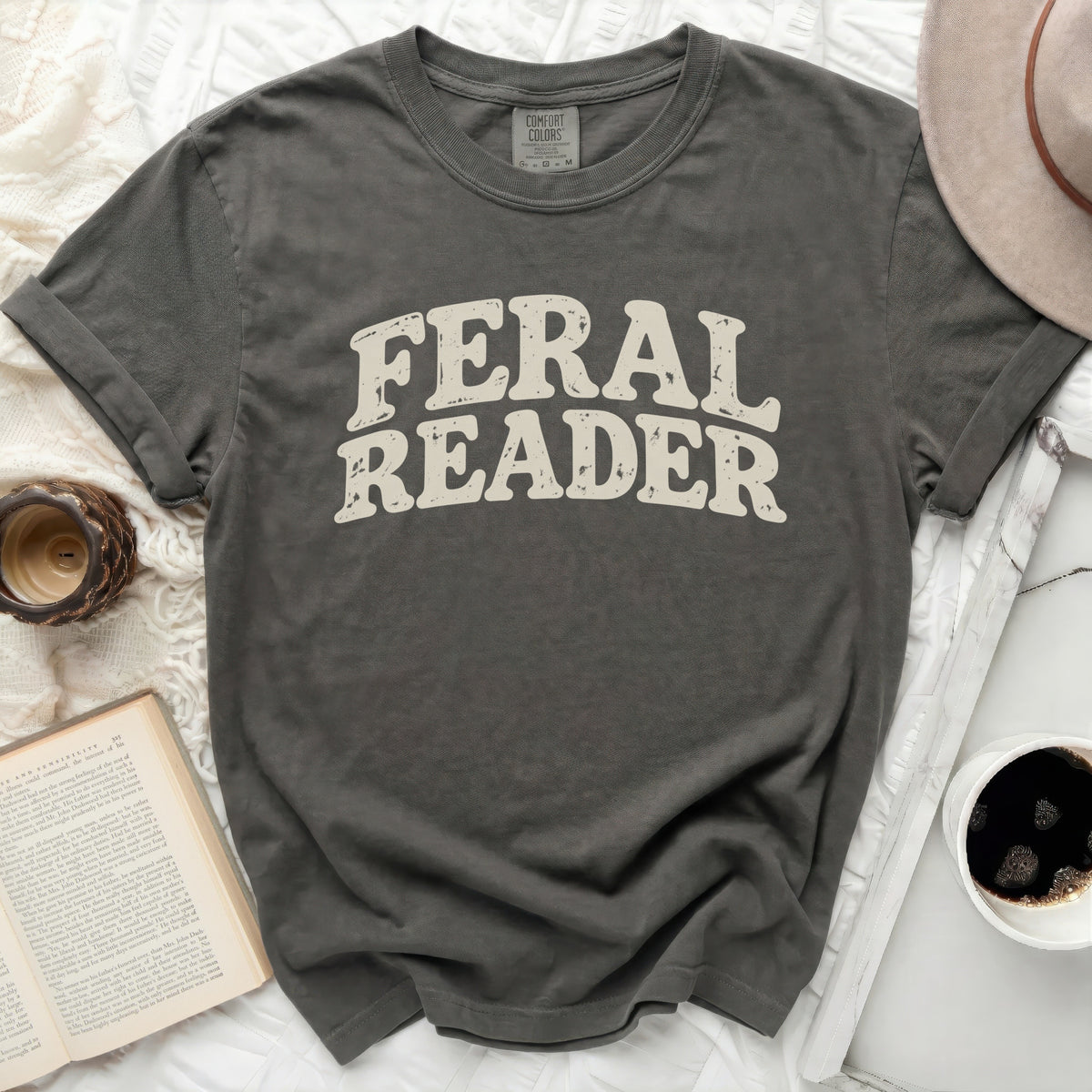Dark grey t-shirt with "FERAL READER" in distressed cream font.