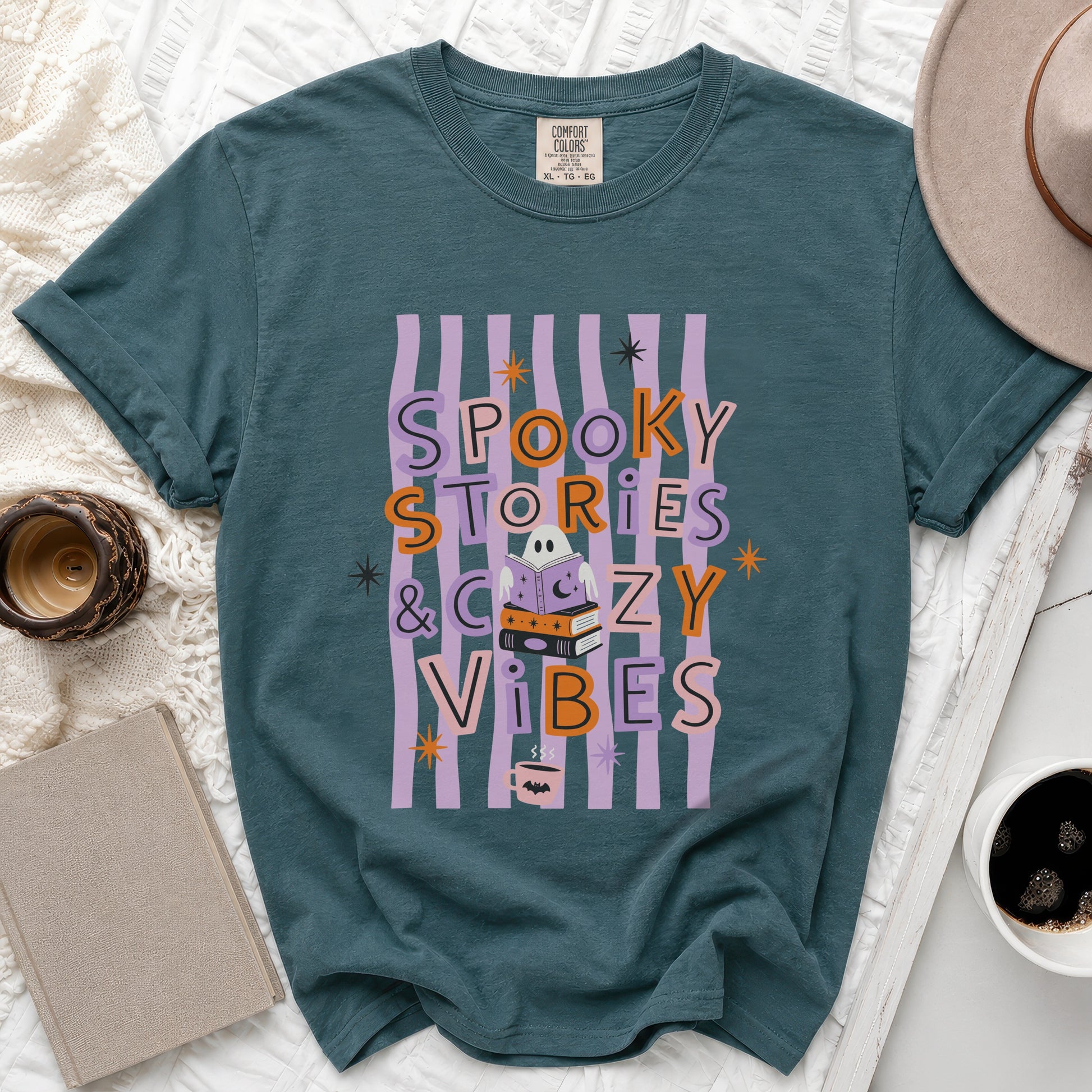 Teal t-shirt with "Spooky Stories & Cozy Vibes" graphic featuring a ghost reading books.