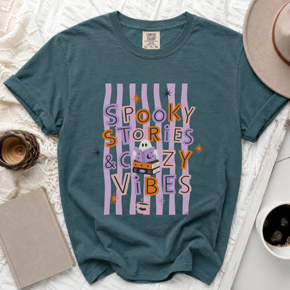 Teal t-shirt with "Spooky Stories & Cozy Vibes" graphic featuring a ghost reading books.