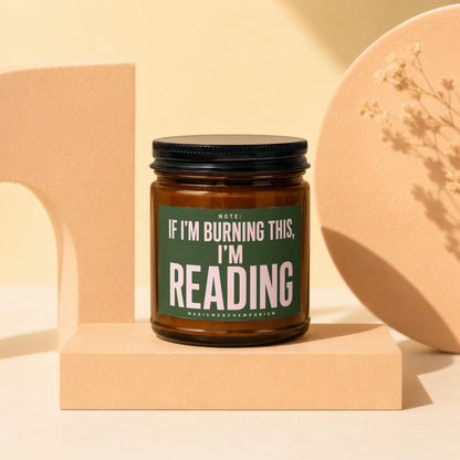 Amber jar candle with green label reading "Note: If I'm burning this, I'm reading."