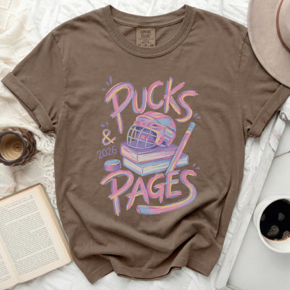 Brown t-shirt with "Pucks & 2026 Pages" graphic and hockey elements.