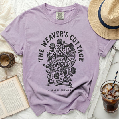 Lavender t-shirt with "The Weaver's Cottage Middle in the Wood" graphic.