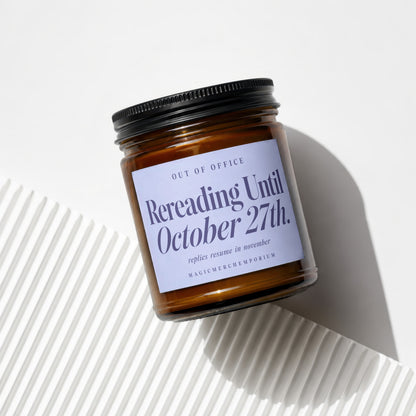 Amber jar candle with a light blue label reading "Rereading Until October 27th."