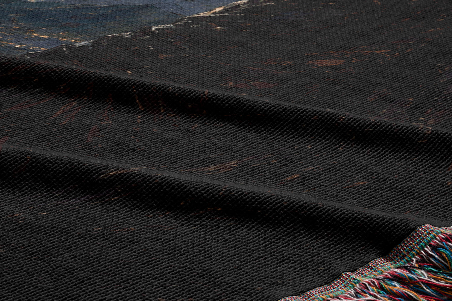 a close-up view of a dark, textured fabric with a subtle pattern. The fabric appears to be a dark-colored textile, possibly a blanket or a textile product. The image does not contain any discernible objects or actions, and there are no specific details provided about the fabric's color or texture.