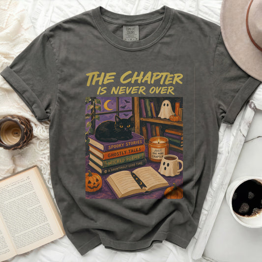 T-shirt with "The Chapter Is Never Over" and Halloween book illustration.