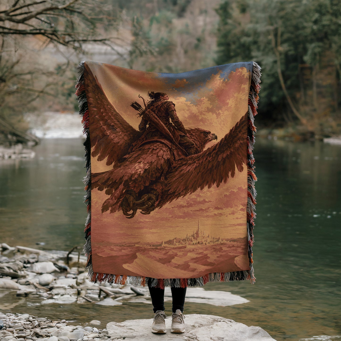 A person stands on a rock, holding a large tapestry or blanket that features a painting of a person riding a winged creature, possibly a dragon or a mythical bird.
