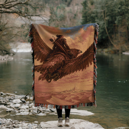 A person stands on a rock, holding a large tapestry or blanket that features a painting of a person riding a winged creature, possibly a dragon or a mythical bird.