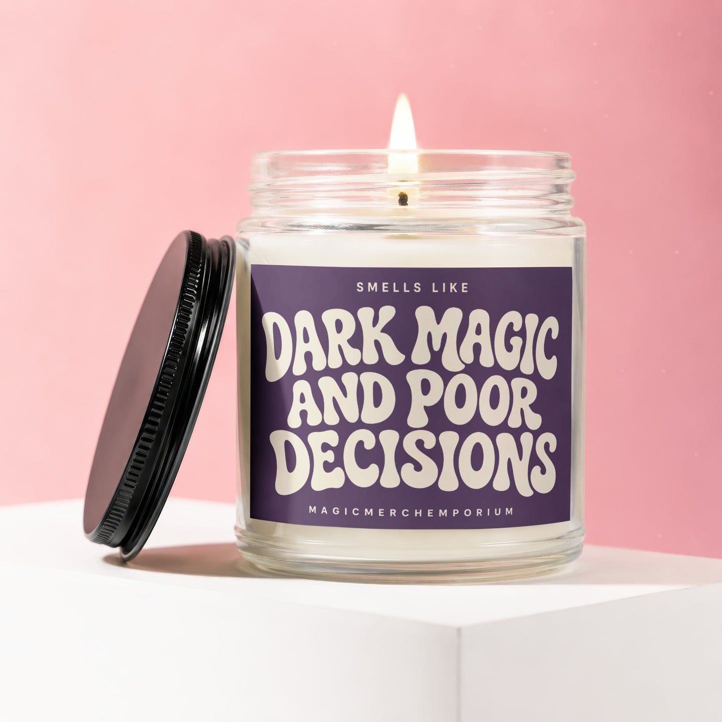 Scented candle with text "SMELLS LIKE DARK MAGIC AND POOR DECISIONS" and "MAGICMERCH™"