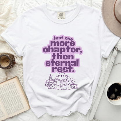 White t-shirt with purple "Just one more chapter, then eternal rest" graphic.