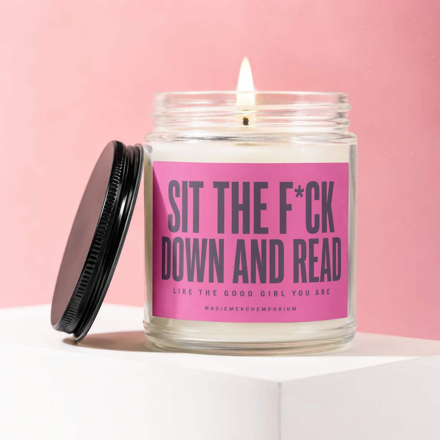 Jar candle with pink label reading "Sit the F*ck Down and Read Like the Good Girl You Are".