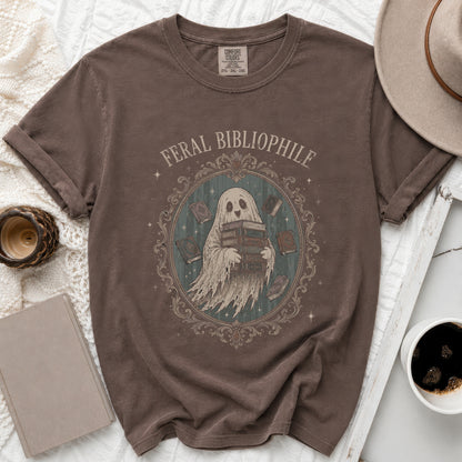 Brown t-shirt with ghost graphic holding books and text "FERAL BIBLIOPHILE".