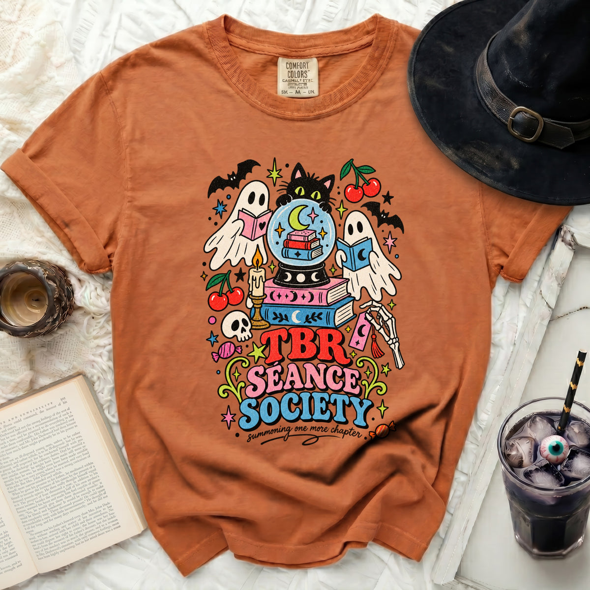 Orange t-shirt with "TBR Seance Society" graphic of ghosts and books.
