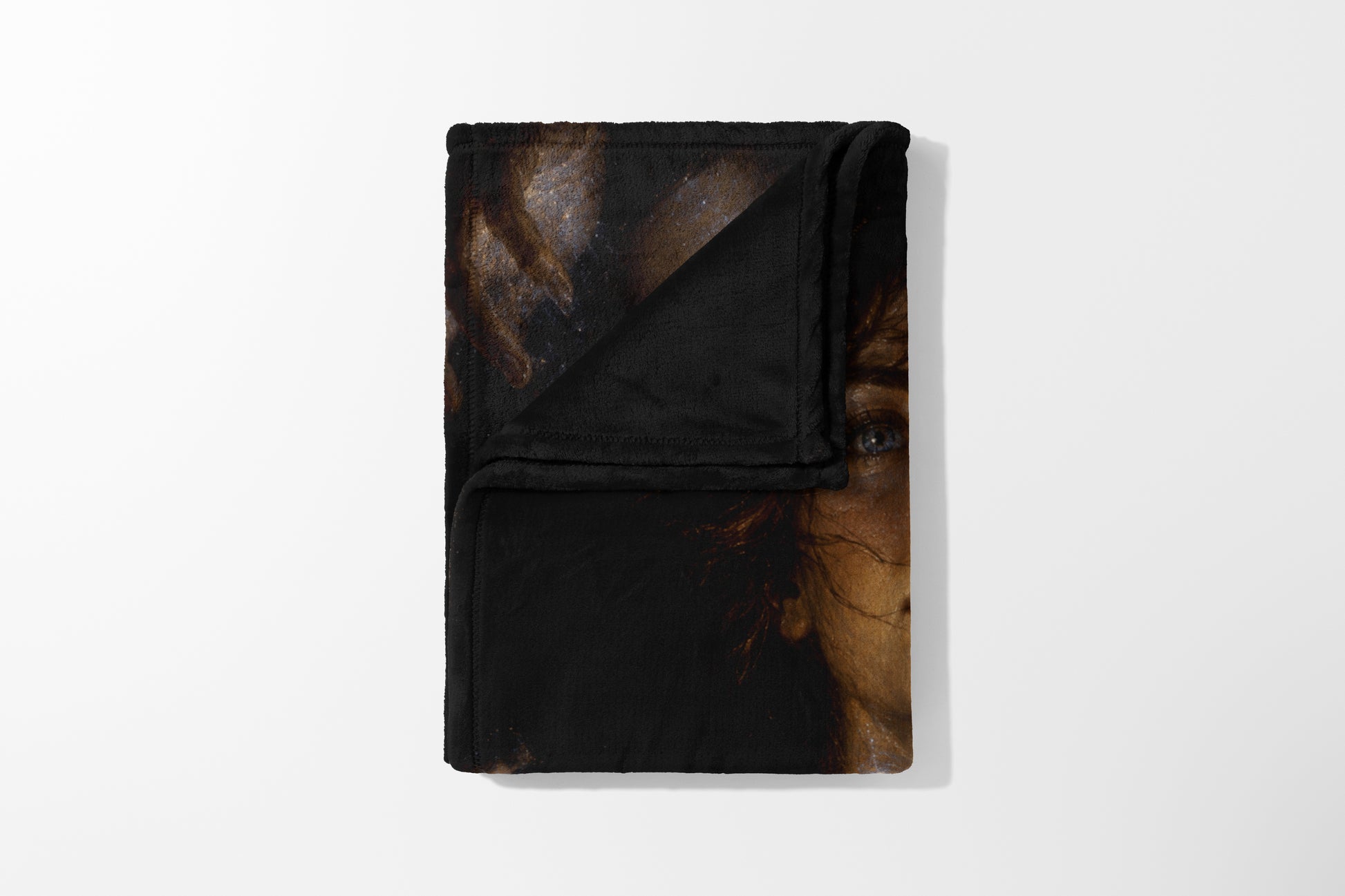Folded blanket featuring a detail of a woman's face, including her eye and hair.