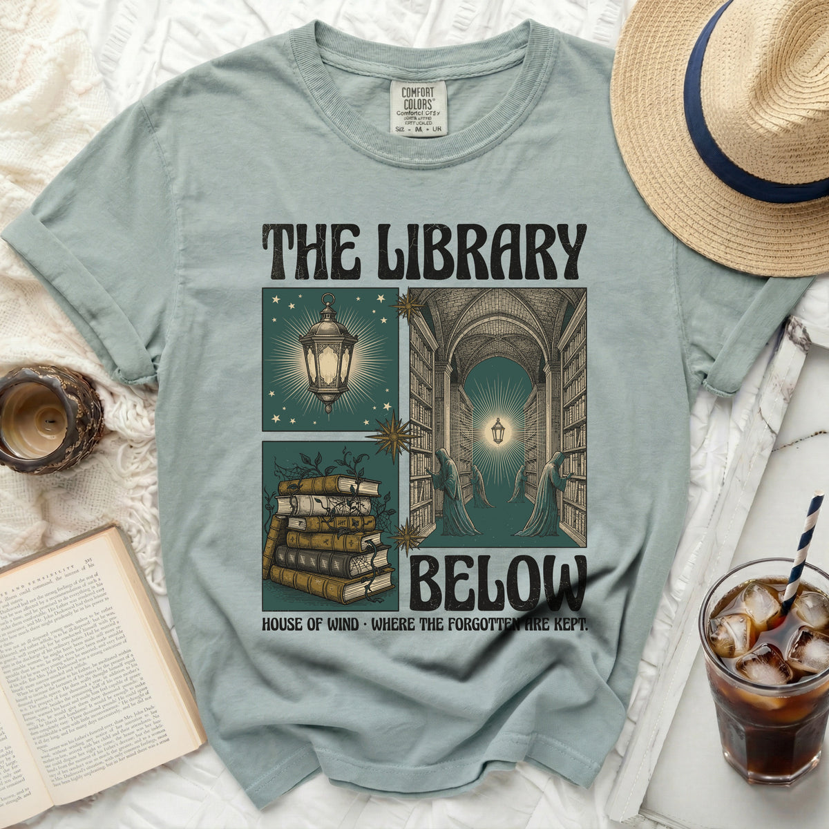 The Library Below shirt design with books, figures, and text.