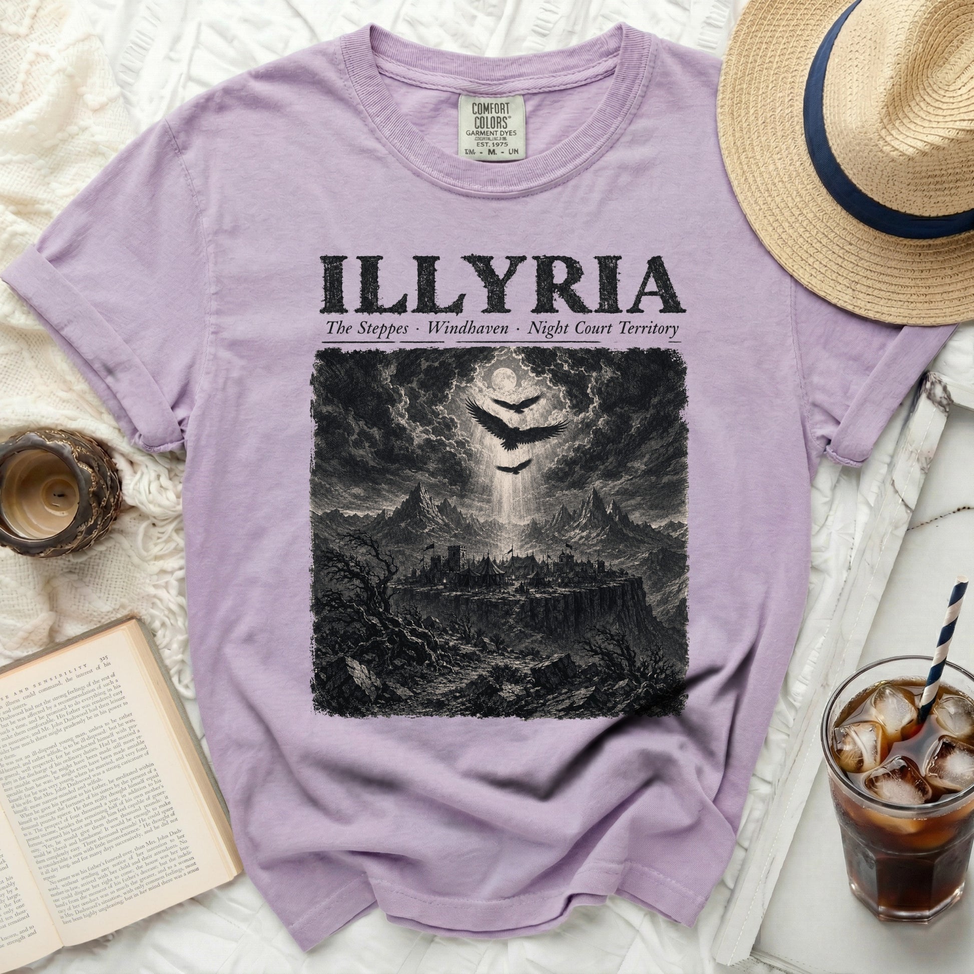 Lilac t-shirt with "ILLYRIA" text and dark fantasy landscape graphic.