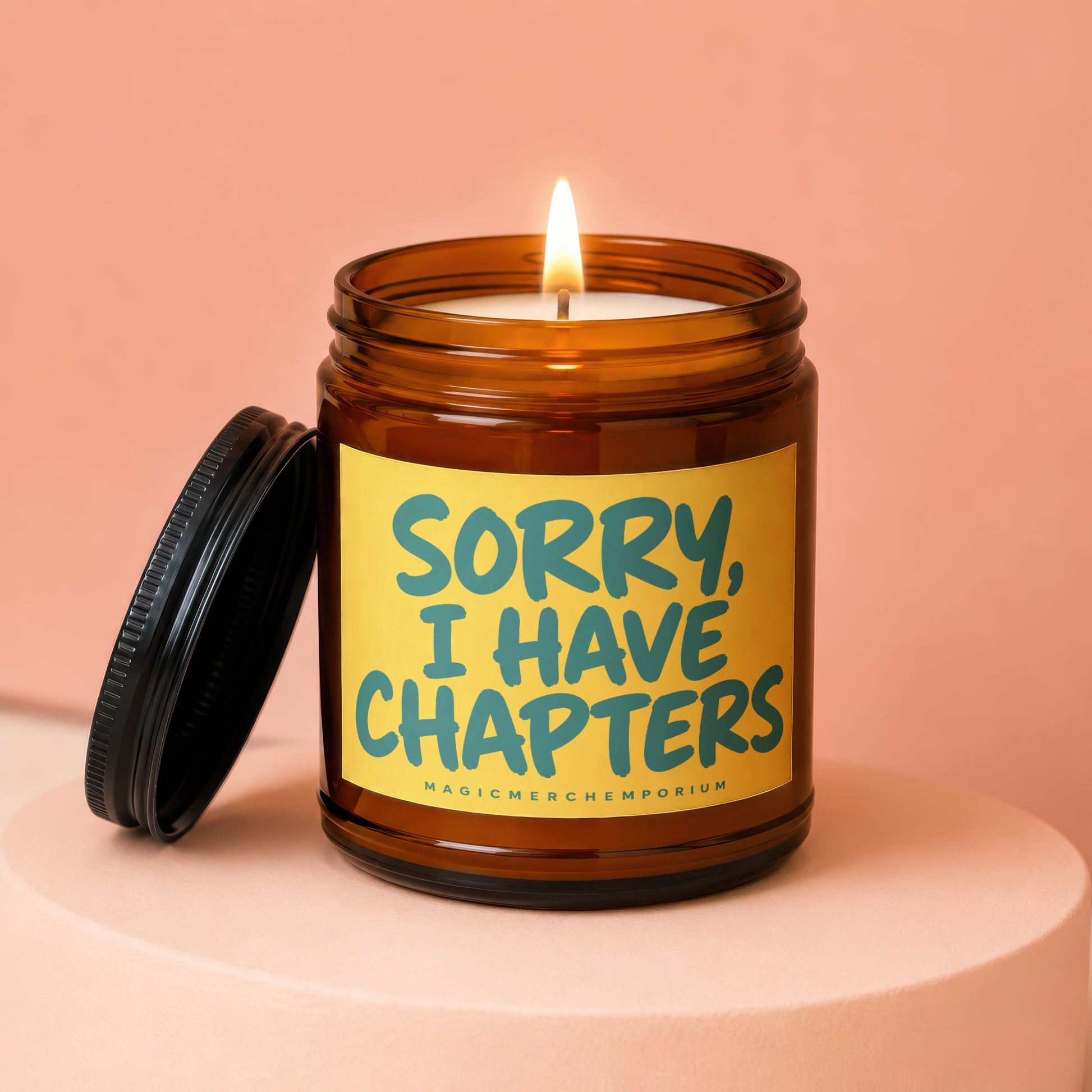 Lit amber candle with black lid, saying "SORRY, I HAVE CHAPTERS".