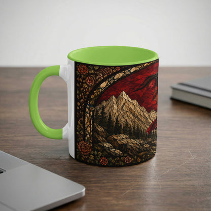 White mug with green handle featuring a stained glass dragon, mountains, and roses design.