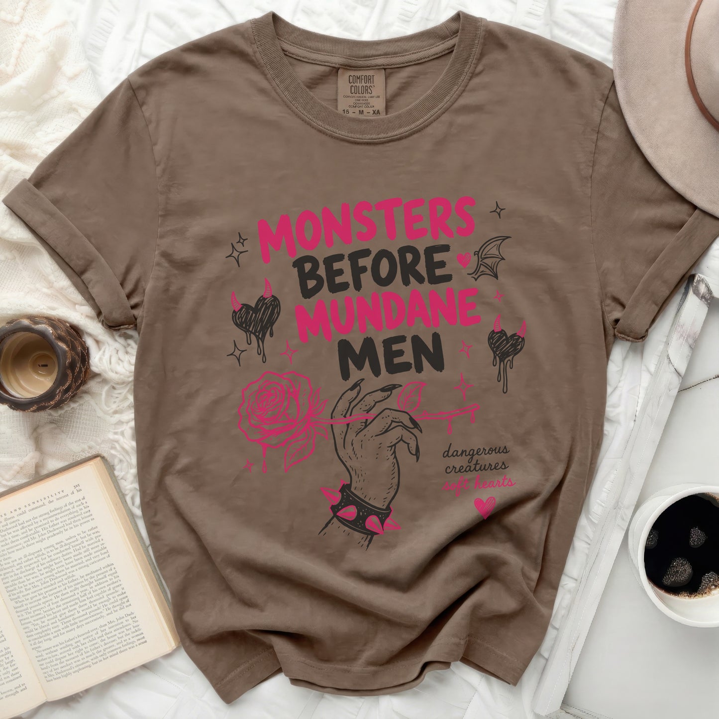 Brown t-shirt with "Monsters Before Mundane Men" text and pink accents.