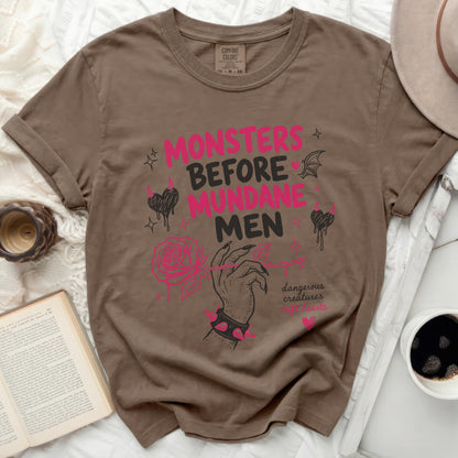 Brown t-shirt with "Monsters Before Mundane Men" text and pink accents.