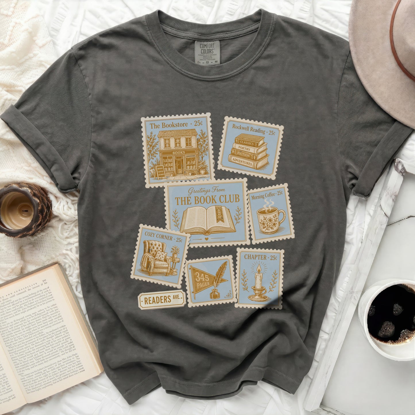 Graphic tee with postage stamp designs for "The Bookstore," "Rockwell Reading," and "Morning Coffee."