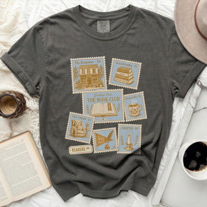 Graphic tee with postage stamp designs for "The Bookstore," "Rockwell Reading," and "Morning Coffee."