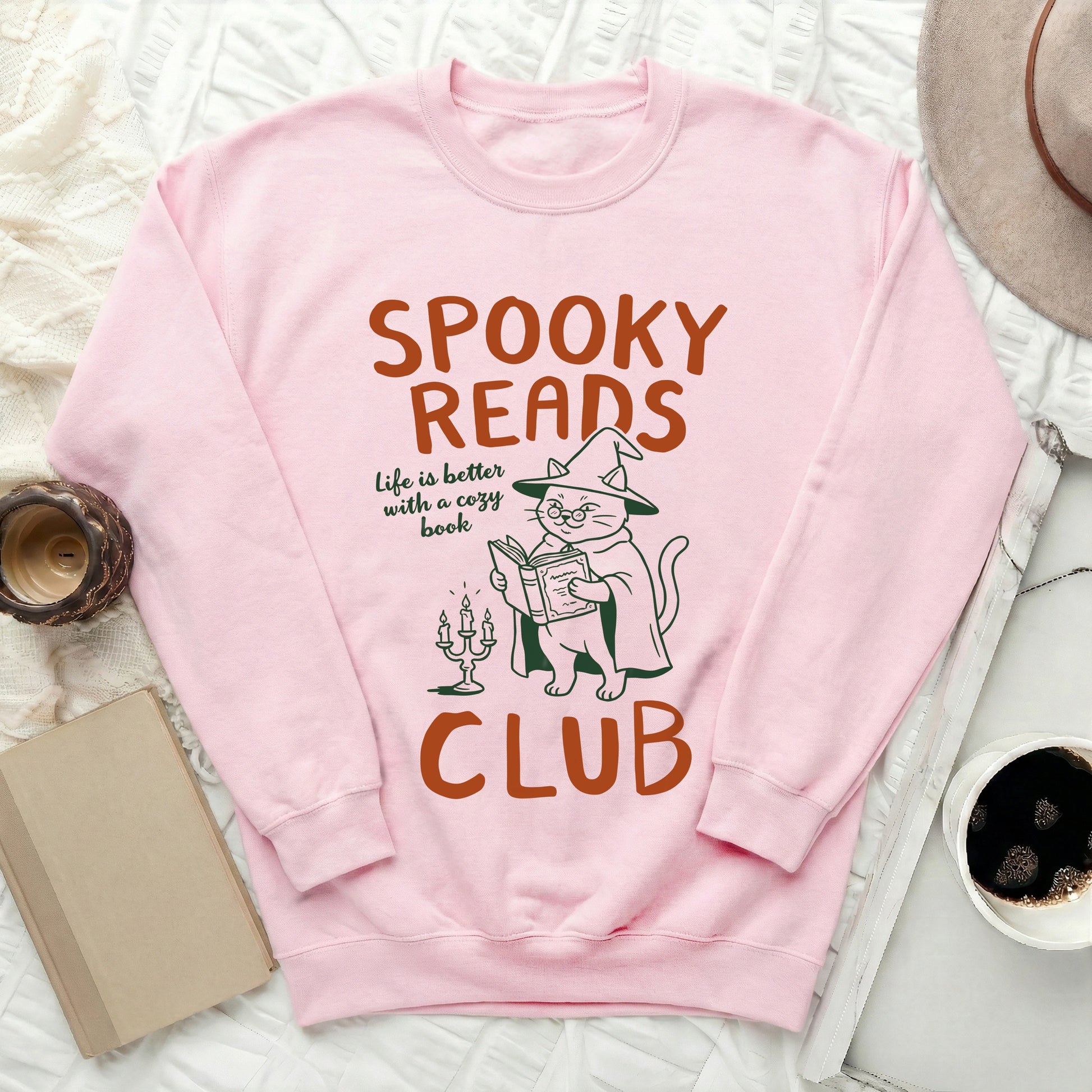 Pink sweatshirt with "Spooky Reads Club" text and a cat reading a book.