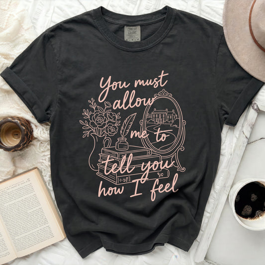 Black t-shirt with pink text and floral design about telling feelings.